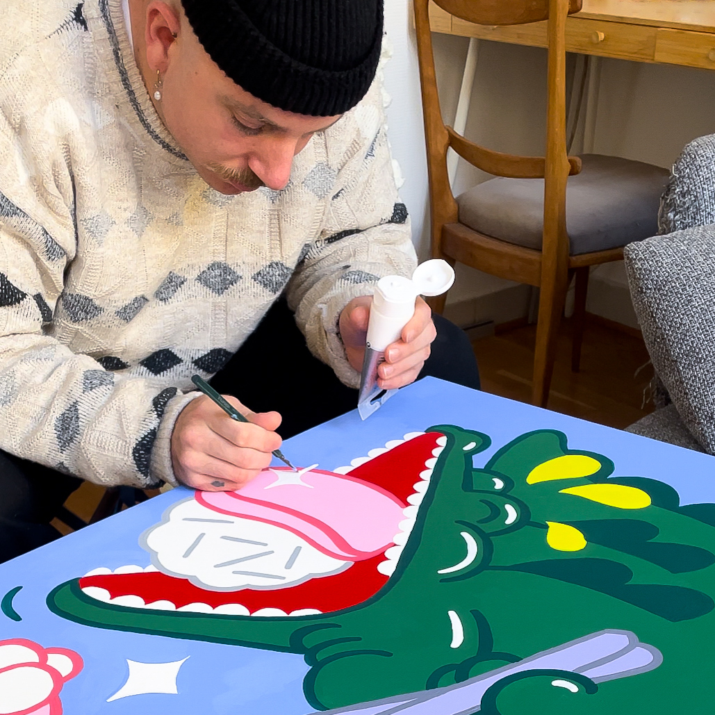 Artist Bambi Bakbi hand painting a crocodile on canvas