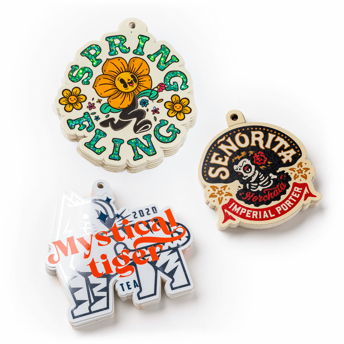 Drei Stapel von gestanzten Aufklebern zum Aufhängen.