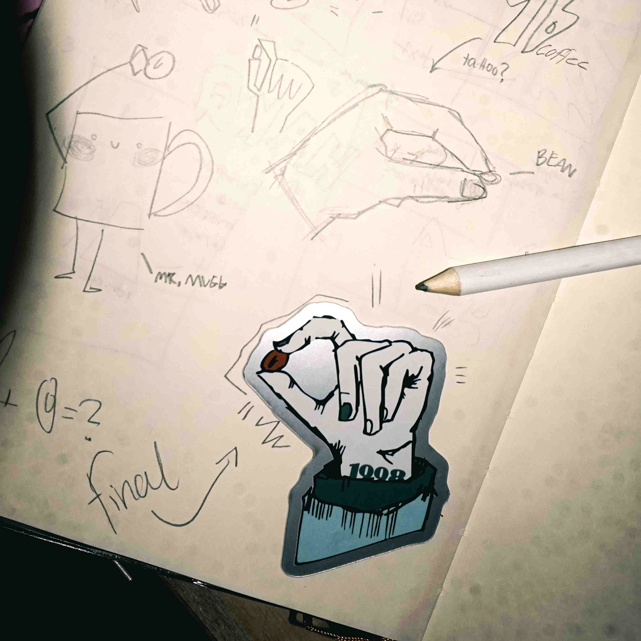 Sketchbook with hand drawings, a pencil, and a sticker of a hand holding a red object. Doodles and notes are visible in the background.