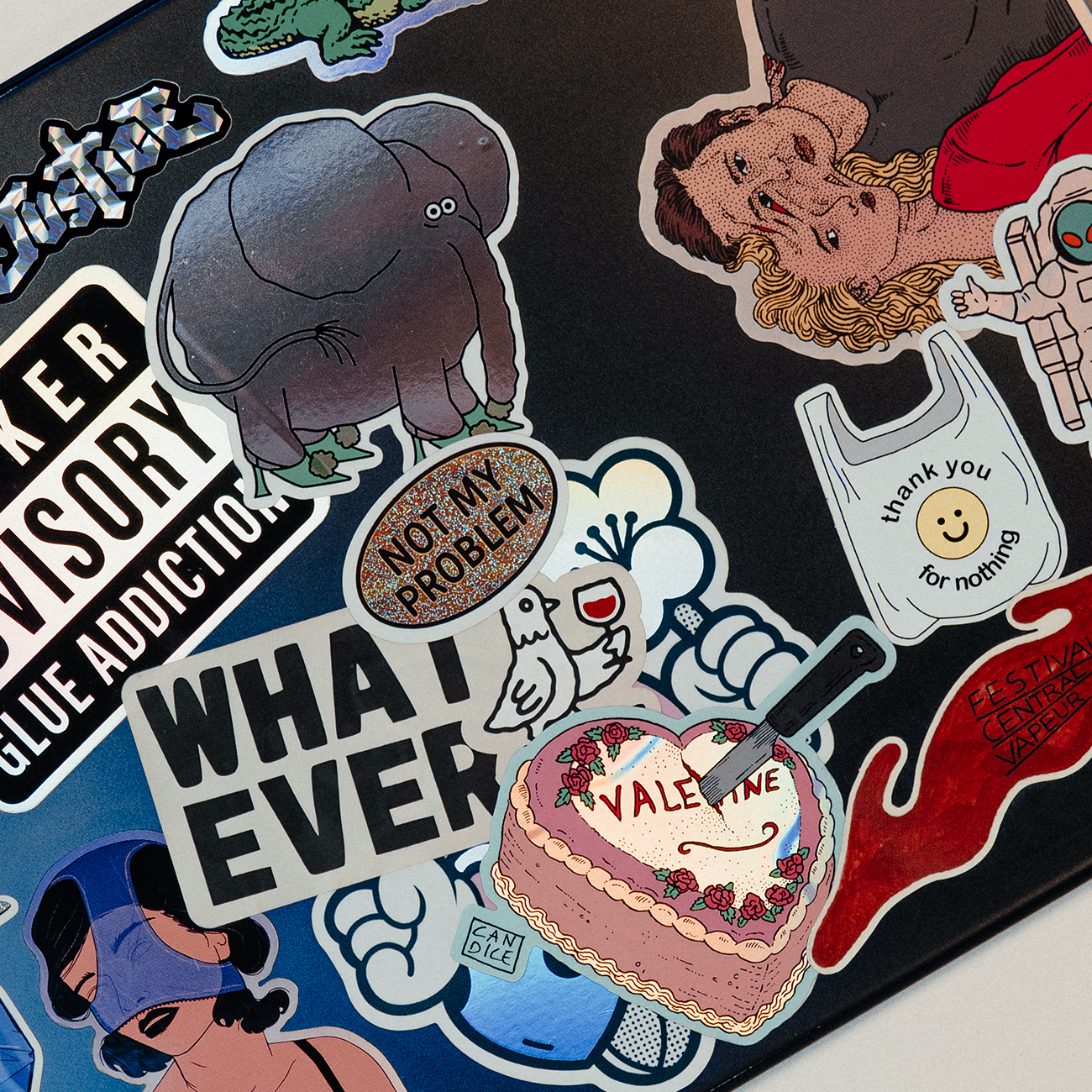 Close-up of a laptop covered in colorful stickers with playful illustrations, characters, and text designs