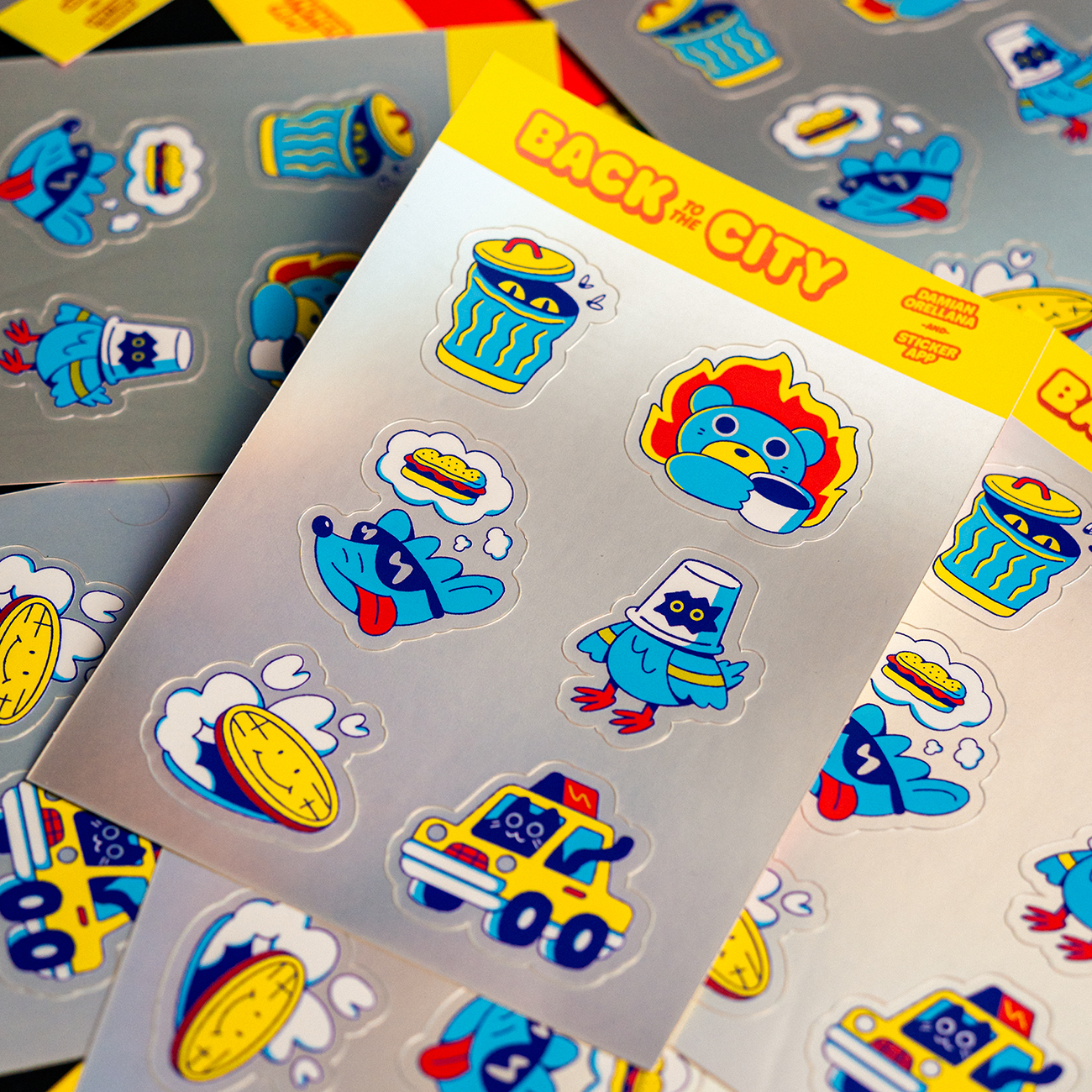 Sheet of colorful stickers with cartoon animals, food, and vehicles on a yellow "Back to the City" background.