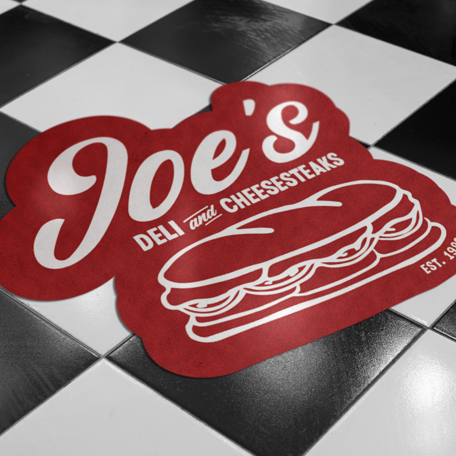 Eigenes Boden-Decal mit Logo als Branding im Laden auf dem Fliesenboden eines Delis