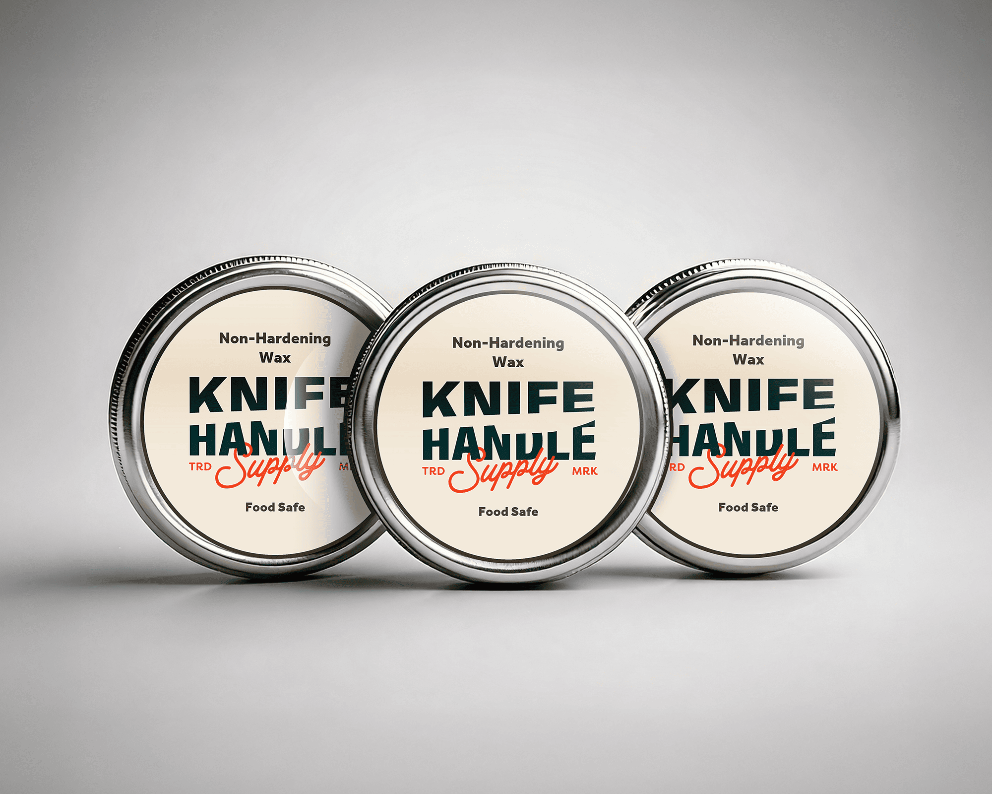 Three tins of non-hardening knife handle wax labeled "Knife Handle Supply," arranged in a row on a gray background.