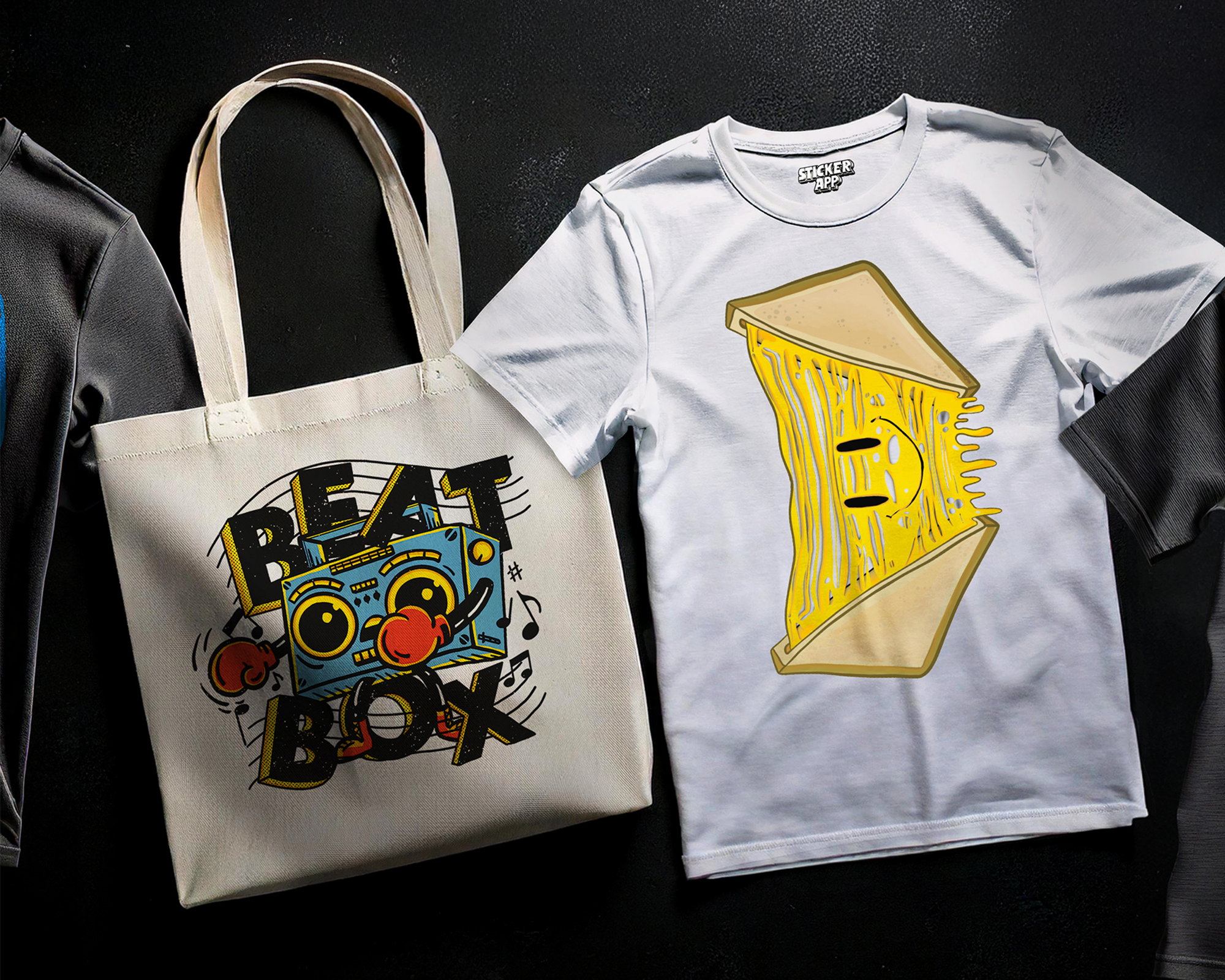 Tote bag with "Beat Box" design and a white T-shirt featuring a stylized sandwich illustration on a dark background.
