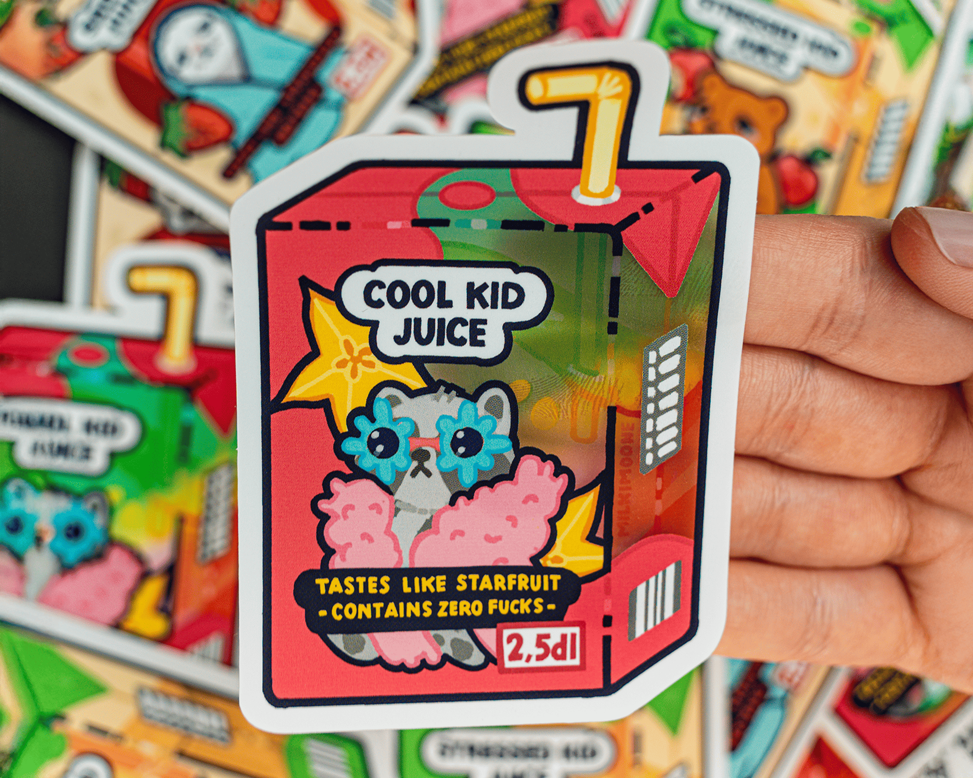 Vinyl sticker of a colorful juice box labeled "Cool Kid Juice" with a cute cartoon animal, stars, and text "Tastes like starfruit - Contains zero f*cks."