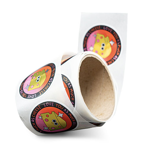 Rolle mit runden Etiketten, die ein Cartoon-Käsestück und den Text "Love You As Much As Cheese" auf schwarzem Hintergrund zeigen.