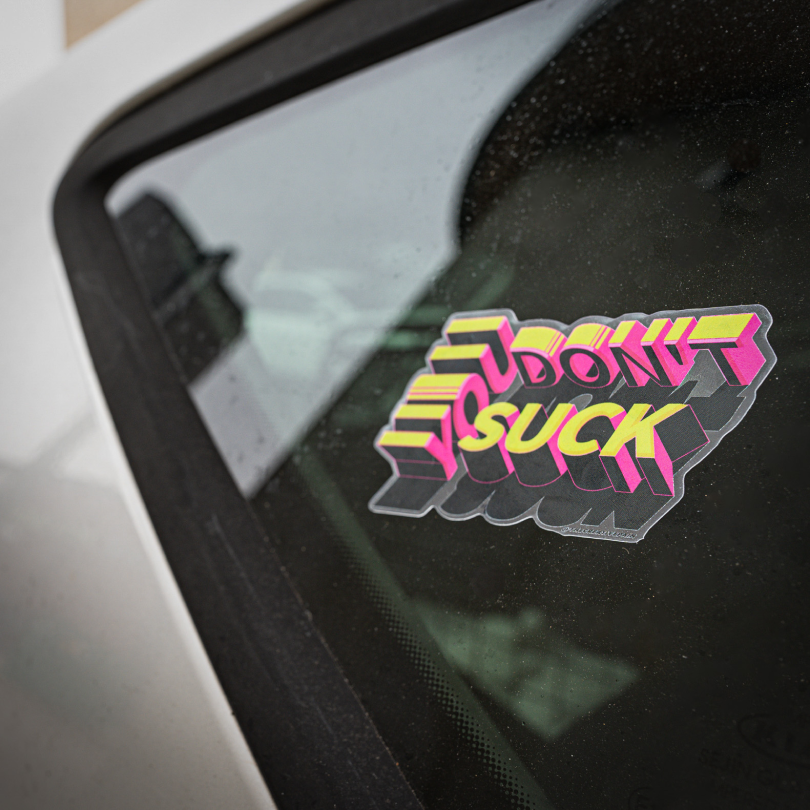 Ein Autoaufkleber, auf dem steht, dass du kein Arschloch bist, an der Seite eines Autos.